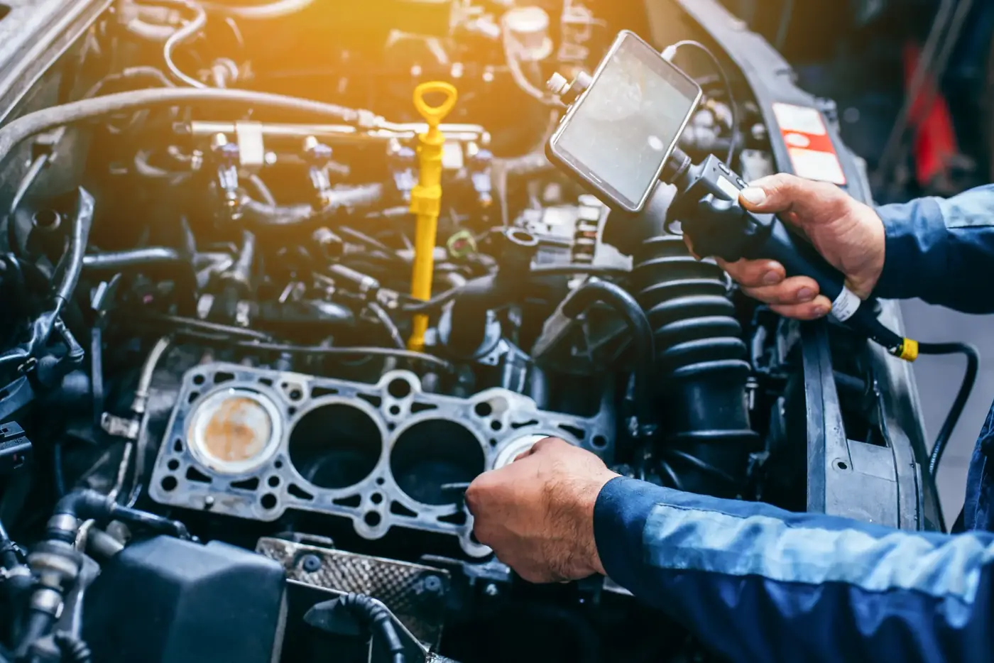 Mechanic using an inspection camera to look inside an engine